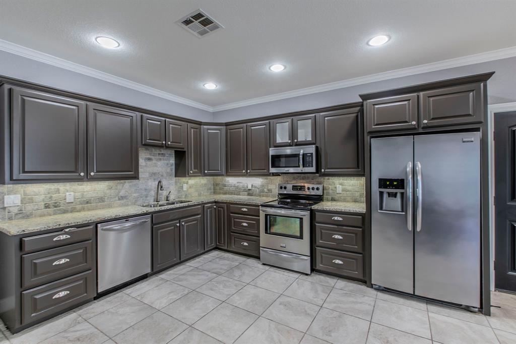20 Independence Trail Waco, TX 76708 - Photo 35 of 40 a kitchen with stainless steel appliances granite countertop a refrigerator and a stove top oven