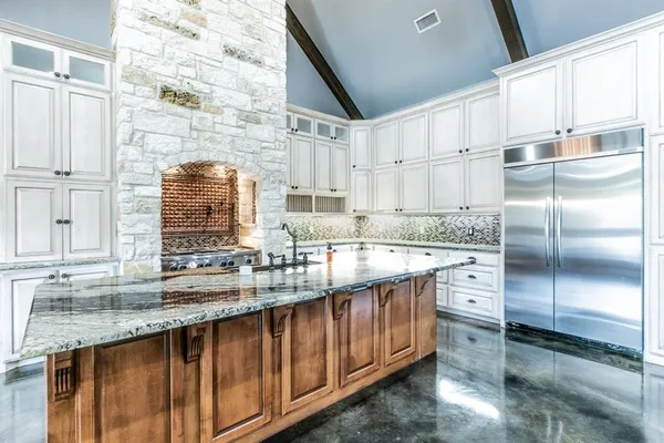 a kitchen with stainless steel appliances granite countertop a sink a stove and a refrigerator