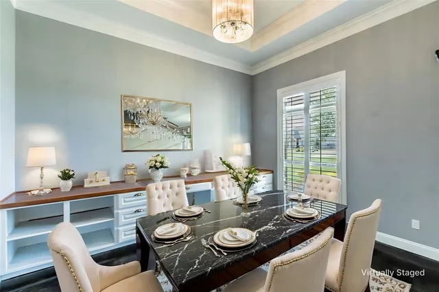 a view of a dining room with furniture a chandelier and wooden floor