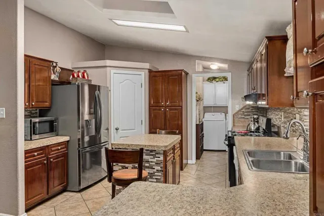 a kitchen with refrigerator and chairs