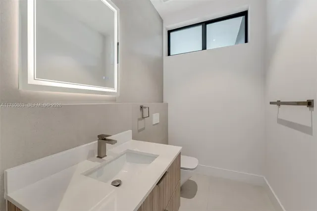 a bathroom with a sink a toilet and mirror