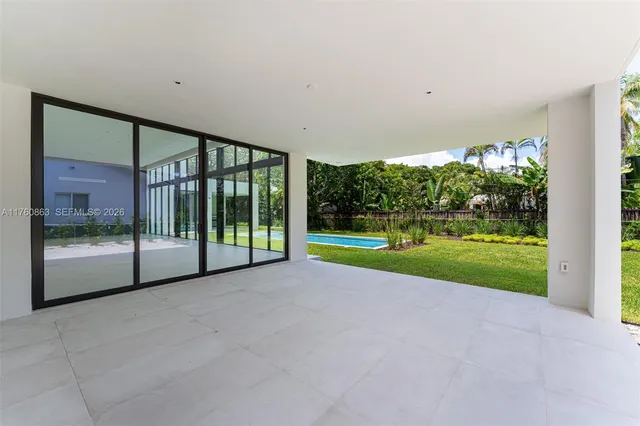 a view of pool with large windows and palm trees