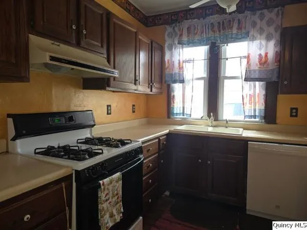 a kitchen with stainless steel appliances a stove a sink and a microwave