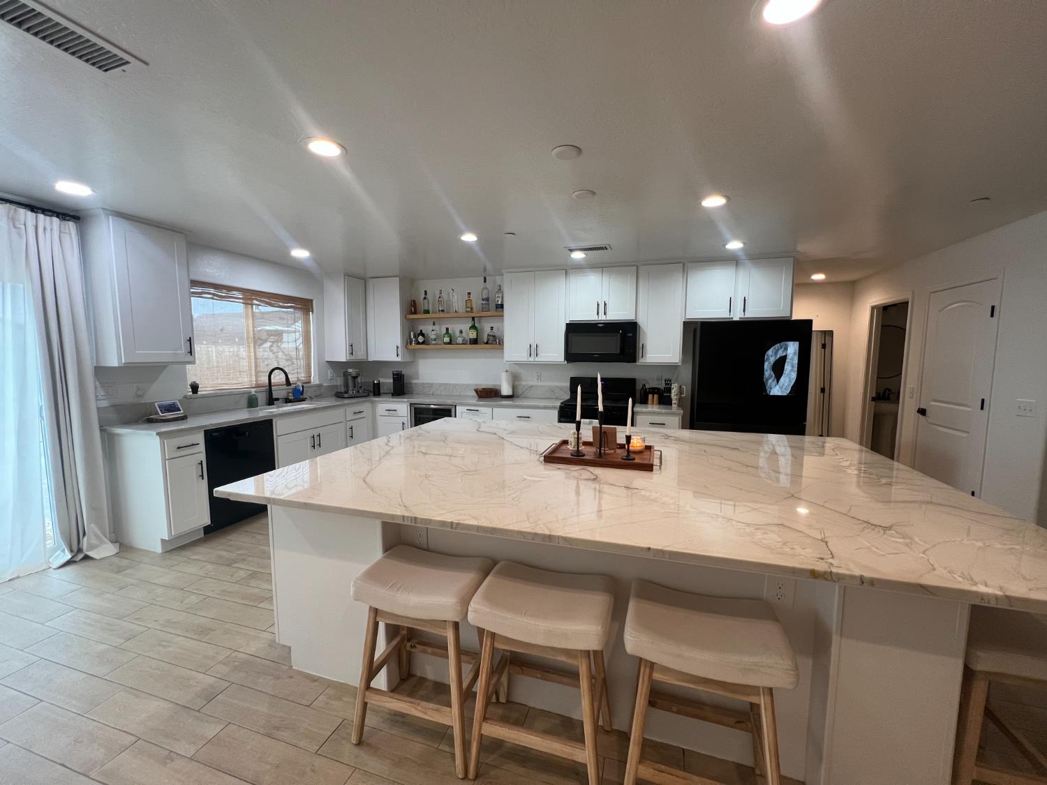 788 Apple Street Dinuba, CA 93618 - Photo 14 of 46 a kitchen with stainless steel appliances kitchen island granite countertop a table chairs sink and cabinets