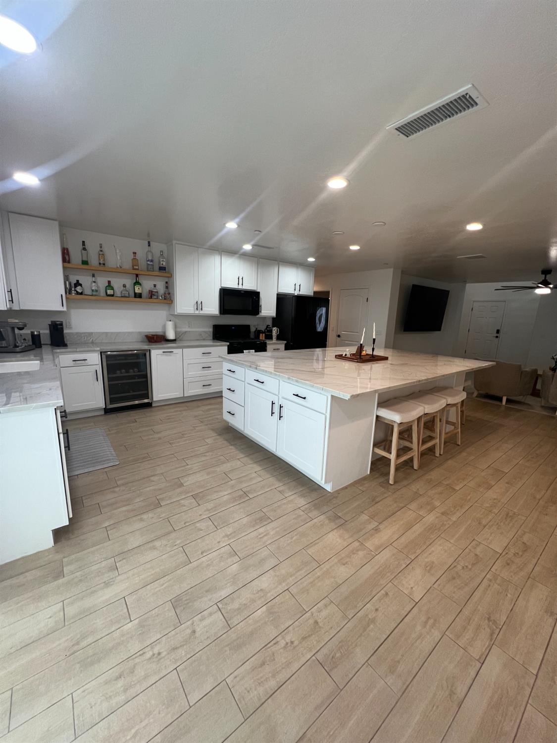 788 Apple Street Dinuba, CA 93618 - Photo 15 of 46 a large white kitchen with stainless steel appliances kitchen island granite countertop a large counter top a stove a sink and a refrigerator