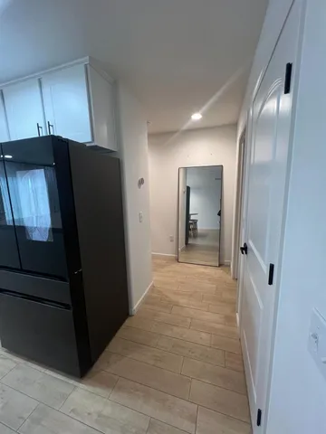 a view of a hallway with wooden cabinets