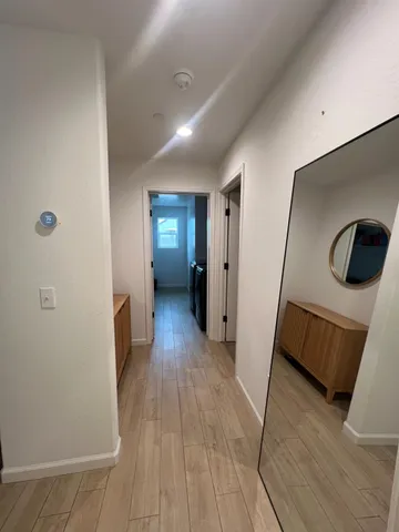 a view of a hallway with wooden floor and furniture