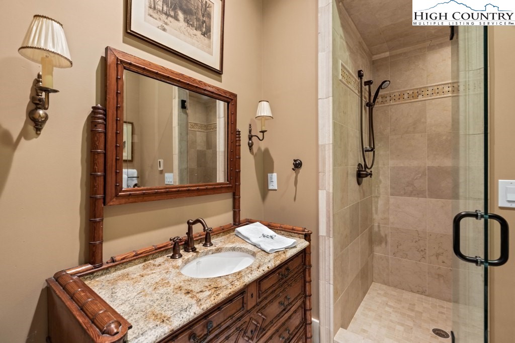 210 Farm Loop Road Banner Elk, NC 28604 - Photo 32 of 48 a bathroom with a granite countertop sink a mirror and shower