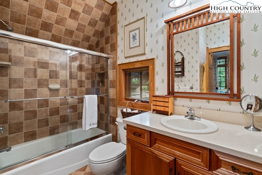 210 Farm Loop Road Banner Elk, NC 28604 - Photo 44 of 48 a bathroom with a granite countertop sink toilet a mirror and shower