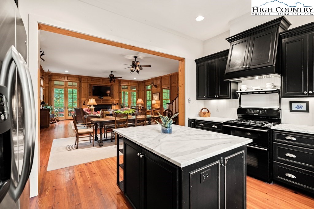210 Farm Loop Road Banner Elk, NC 28604 - Photo 8 of 48 a kitchen with stainless steel appliances granite countertop a refrigerator a stove top oven a sink dishwasher and white cabinets with wooden floor