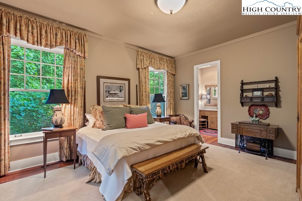 210 Farm Loop Road Banner Elk, NC 28604 - Photo 10 of 48 a bedroom with a bed a large window with table and chairs