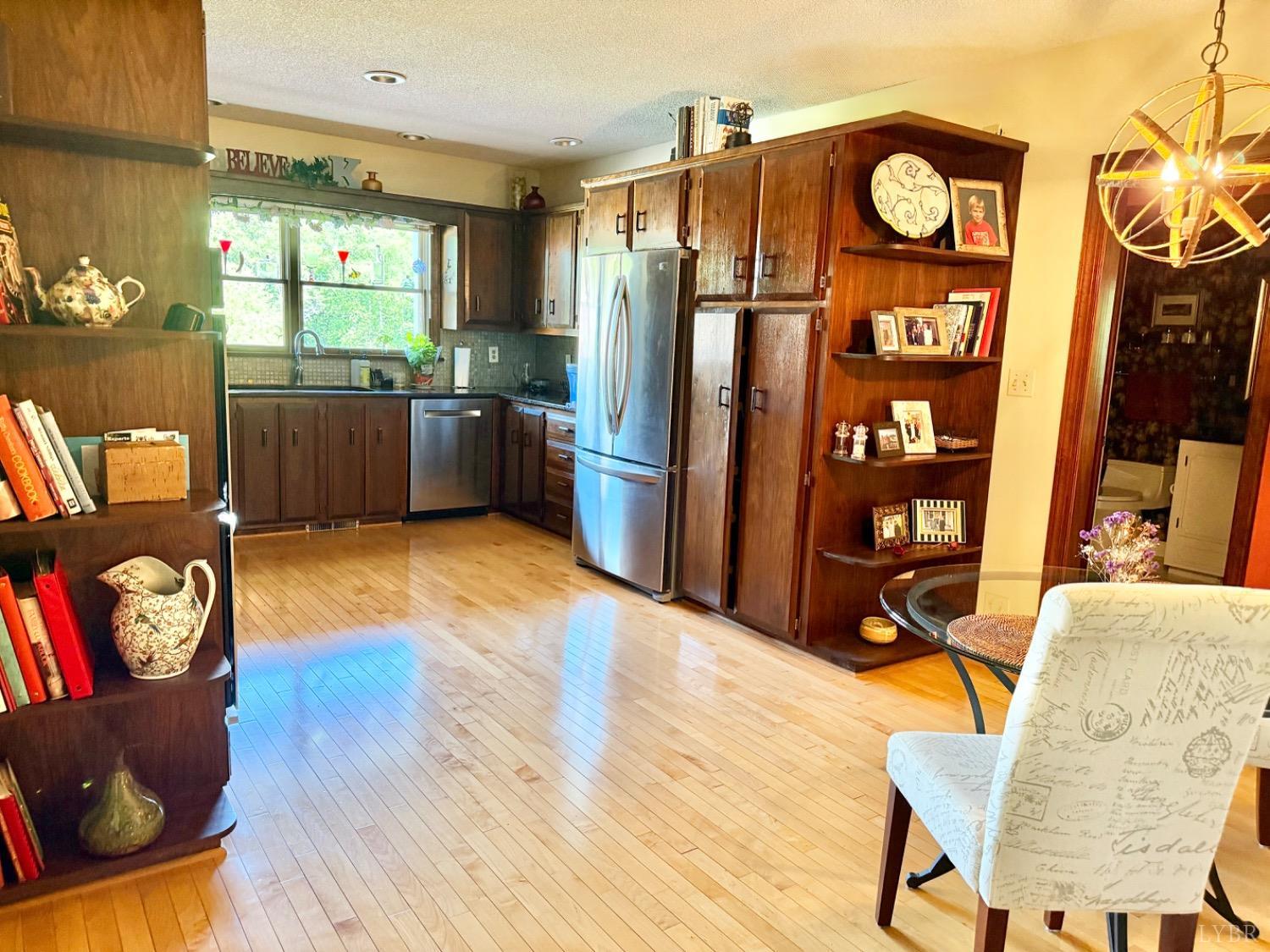 306 Quail Meadows Drive Forest, VA 24551 - Photo 12 of 57 a kitchen with stainless steel appliances wooden floors and wooden cabinets