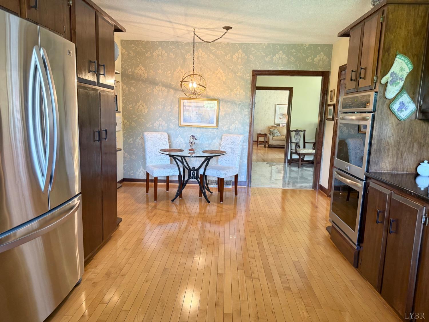306 Quail Meadows Drive Forest, VA 24551 - Photo 14 of 57 a kitchen with stainless steel appliances granite countertop a refrigerator a stove and a wooden floors