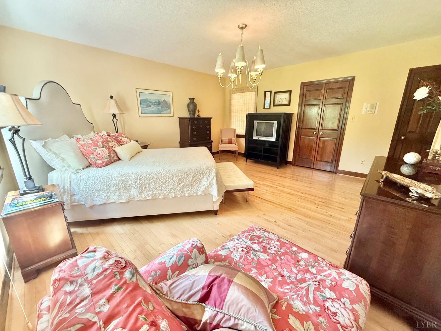 306 Quail Meadows Drive Forest, VA 24551 - Photo 18 of 57 a bedroom with a bed and wooden floor