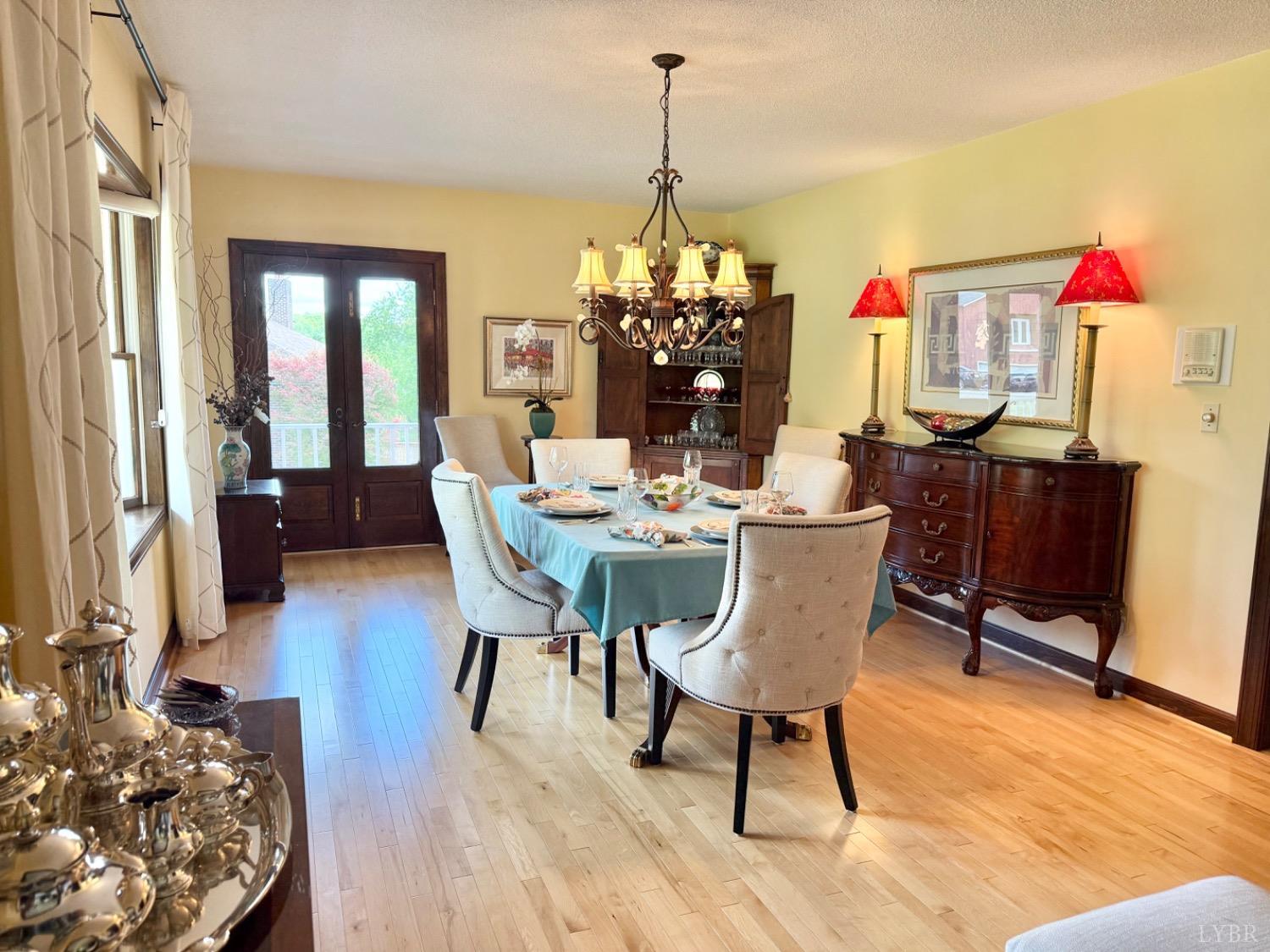 306 Quail Meadows Drive Forest, VA 24551 - Photo 7 of 57 a dining room with wooden floor a chandelier a wooden table and chairs