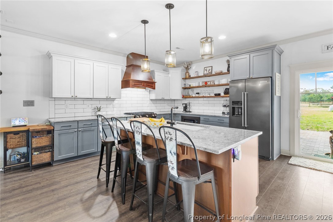5535 Butler Nursery Road Fayetteville, NC 28306 - Photo 12 of 50 a kitchen with kitchen island a stove a table and chairs in it