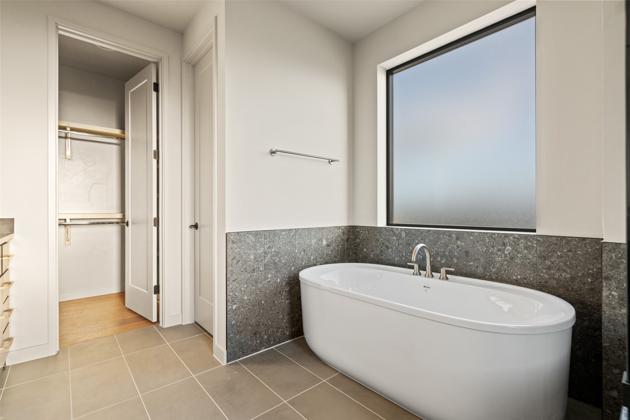 9803 Ribelin Ranch Court, Unit 19 Austin, TX 78750 - Photo 9 of 14 Unwind in the pristine soaking tub, set against sophisticated tiled wainscoting.