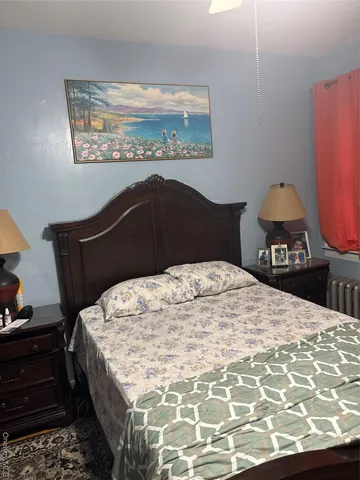 a bedroom with a bed and a painting on the wall