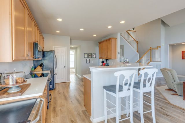 a kitchen with stainless steel appliances kitchen island granite countertop a kitchen island hardwood floor and a sink