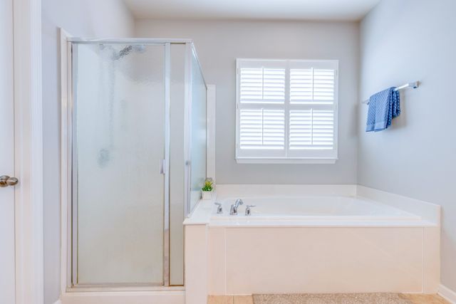 a white bath tub sitting in a bathroom next to a window