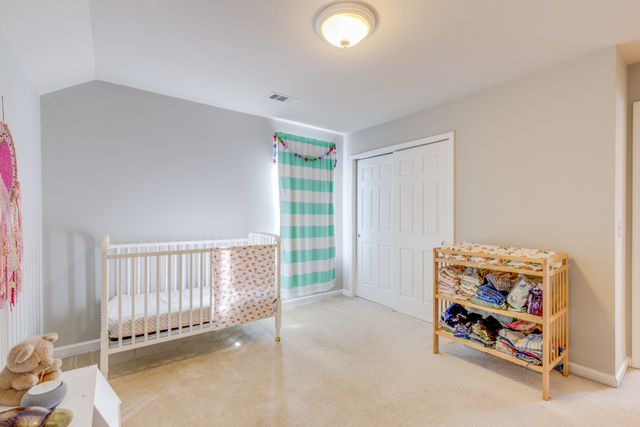 a bedroom with a bed and a flat tv screen on dresser