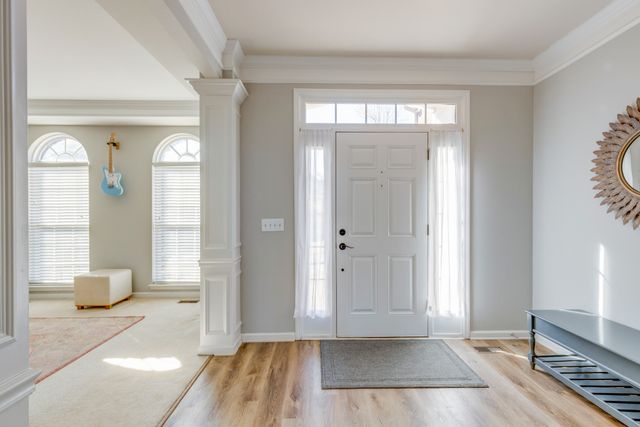 a view of empty room with window and wooden floor