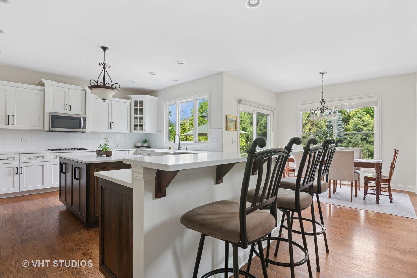 76 Landon Circle Wheaton, IL 60189 - Photo 7 of 51 a kitchen with stainless steel appliances a dining table chairs stove and white cabinets