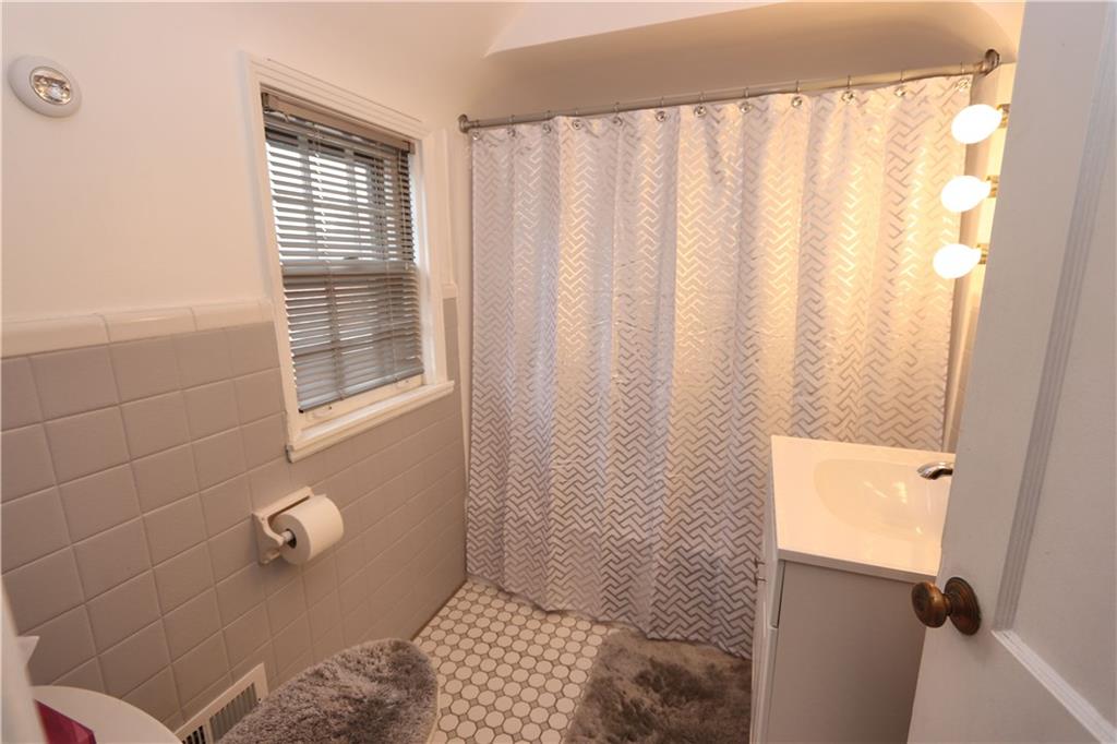 511 Bower Hill Road Pittsburgh, PA 15228 - Photo 10 of 25 Bathroom with Pleasing Updates. Grey tile with new coordinating tile floor. Newer Vanity, Commode and Tub Surround.
