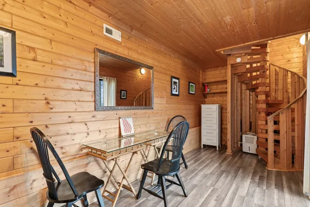 a view of a backyard with large trees and wooden fence