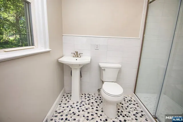 a bathroom with a toilet a sink and a window