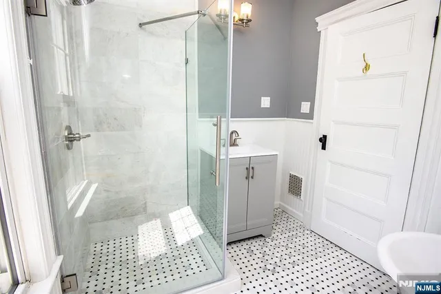 a bathroom with a sink a toilet a shower and a mirror