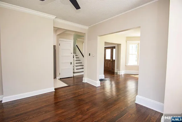 an empty room with wooden floor and stairs