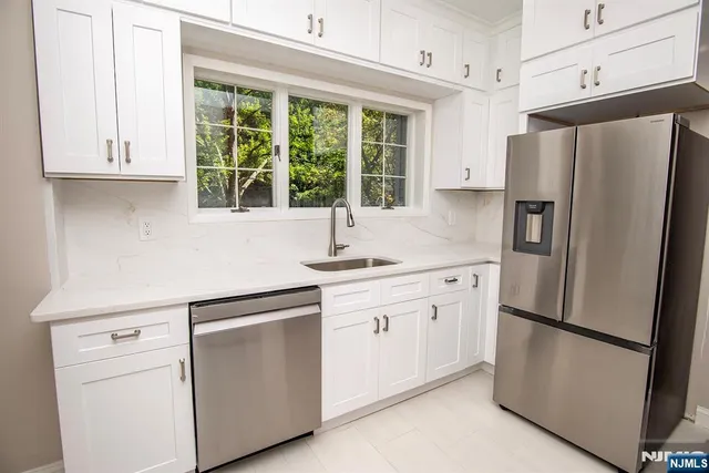 a kitchen with white cabinets and refrigerator