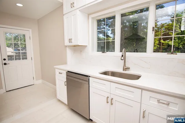 a kitchen with white cabinets and a sink