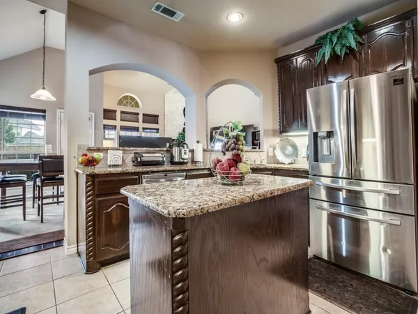 a kitchen with stainless steel appliances granite countertop a sink a stove and a refrigerator