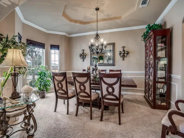 a view of a dining room with furniture and chandelier