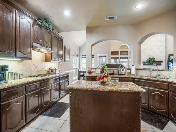 a kitchen with stainless steel appliances granite countertop a sink a stove and cabinets