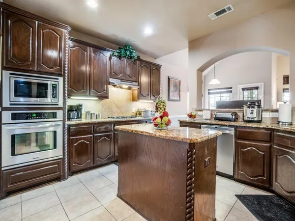 a kitchen with granite countertop a stove top oven microwave and cabinets