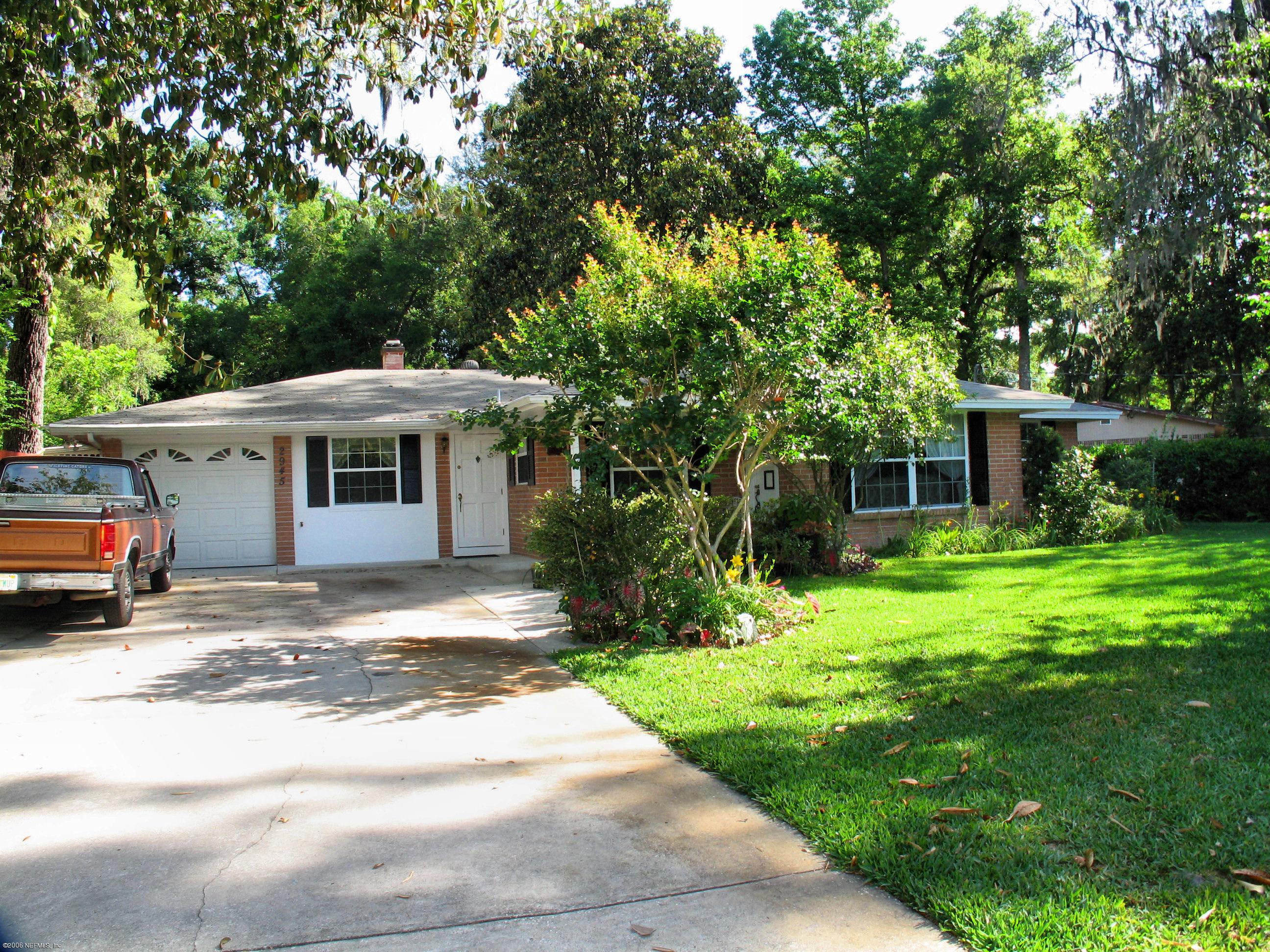 2945 Holly Road Orange Park, FL 32065 - Photo 2 of 5 a view of a white house in front of a yard with potted plants and large trees