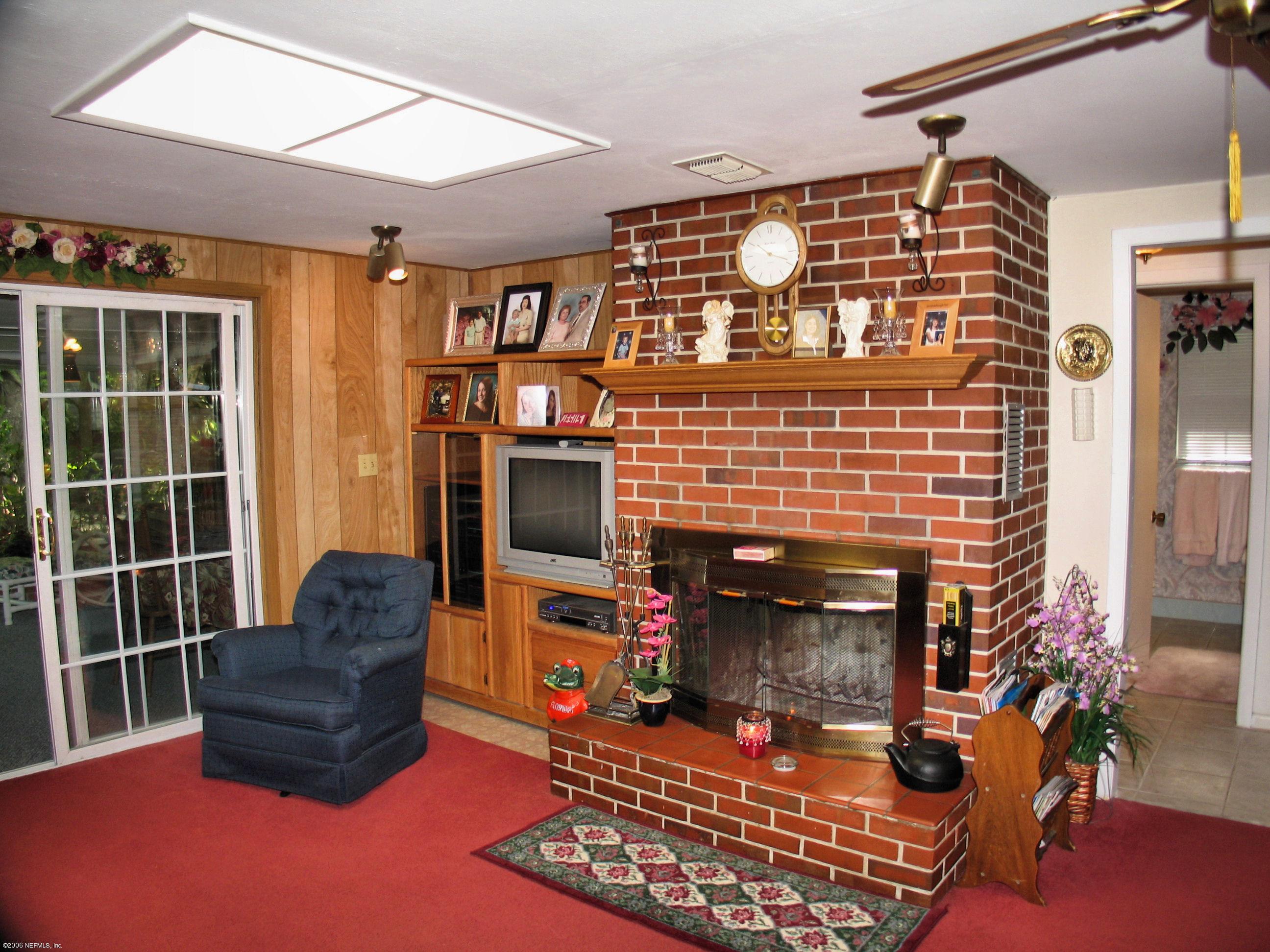 2945 Holly Road Orange Park, FL 32065 - Photo 3 of 5 a living room with furniture a flat screen tv and a fireplace