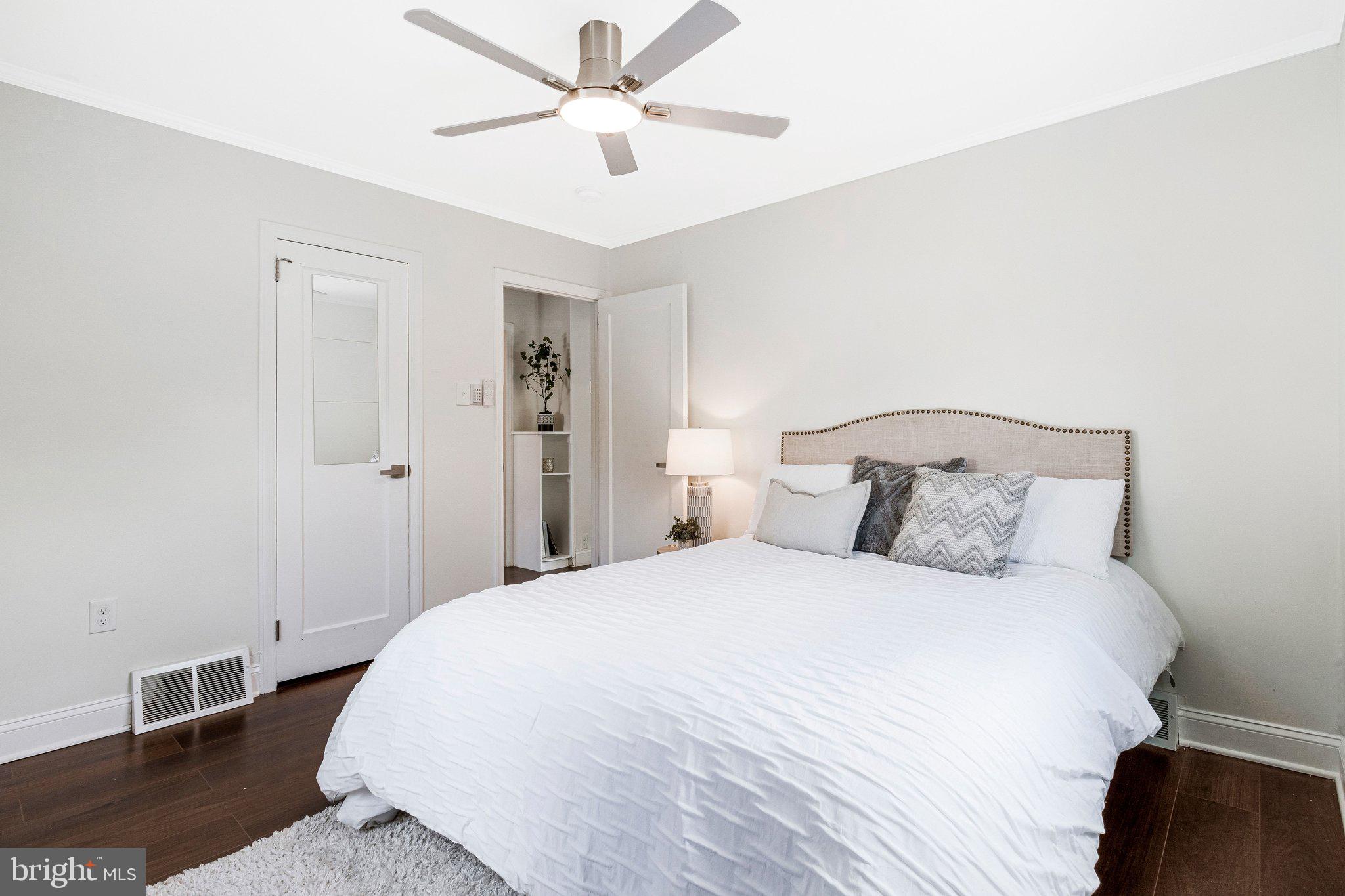 11515 Goodloe Road Silver Spring, MD 20906 - Photo 5 of 33 a bedroom with a large bed and a chandelier fan