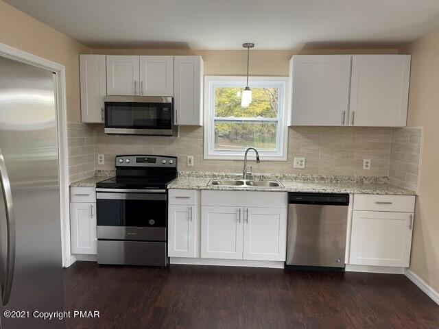 2115 Bushkill Circle Bushkill, PA 18324 - Photo 6 of 42 a kitchen with stainless steel appliances granite countertop a stove a sink and a microwave