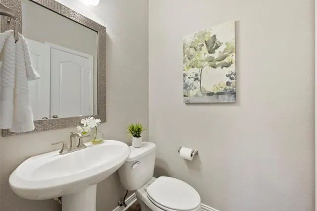 a bathroom with a sink a toilet and a mirror