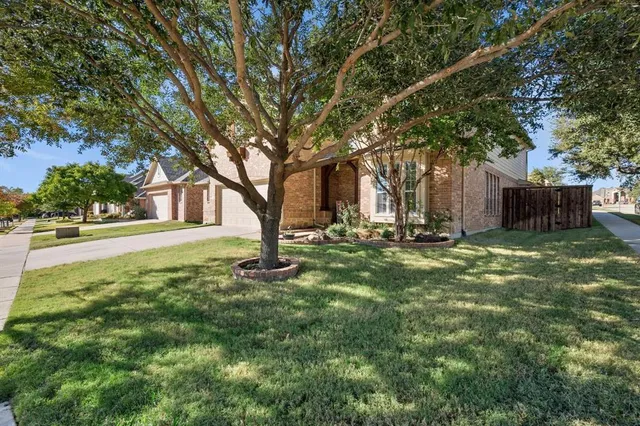 a view of a house with backyard and tree