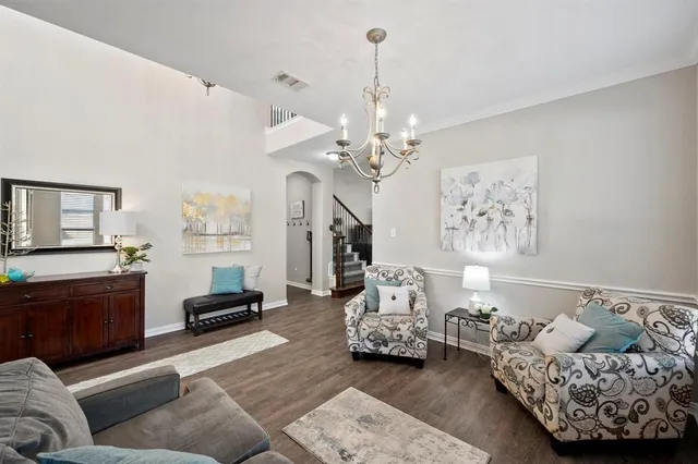a living room with furniture and a chandelier