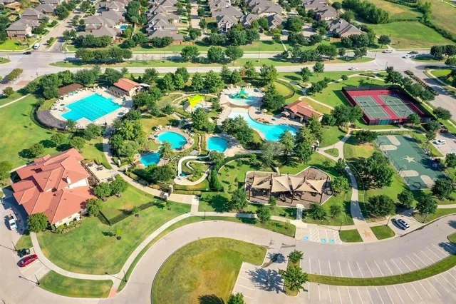 view of a swimming pool with a yard and plants