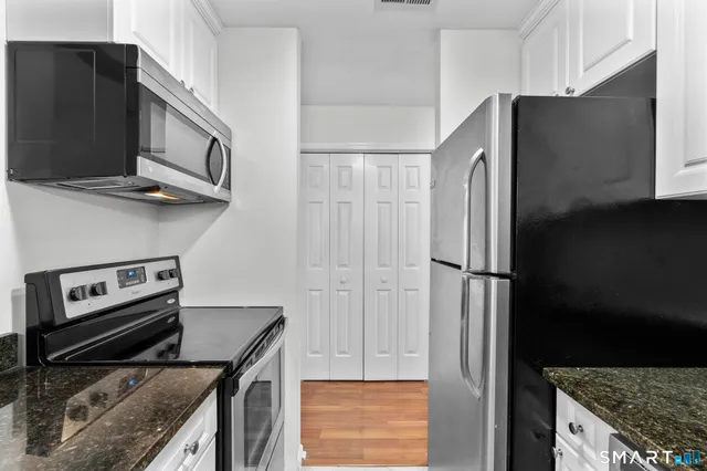 a kitchen with stainless steel appliances granite countertop a refrigerator and a stove