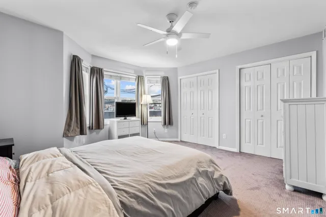 a bedroom with a large bed and a ceiling fan