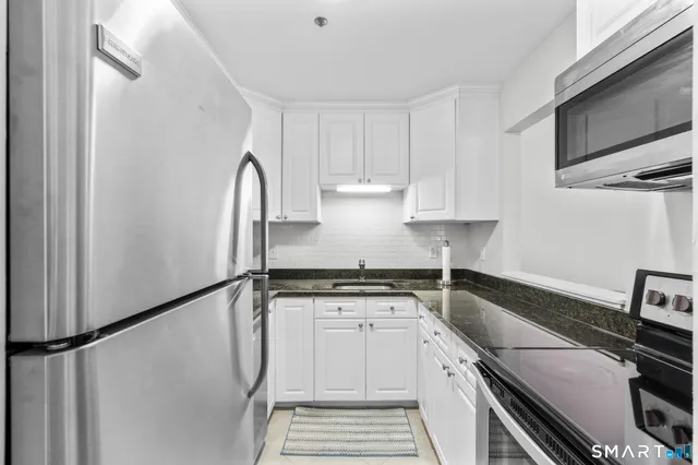 a kitchen with granite countertop a stove sink and cabinets