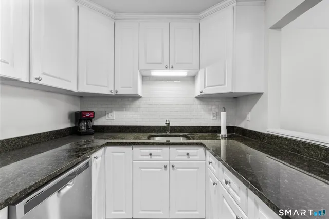 a kitchen with granite countertop a sink and cabinets